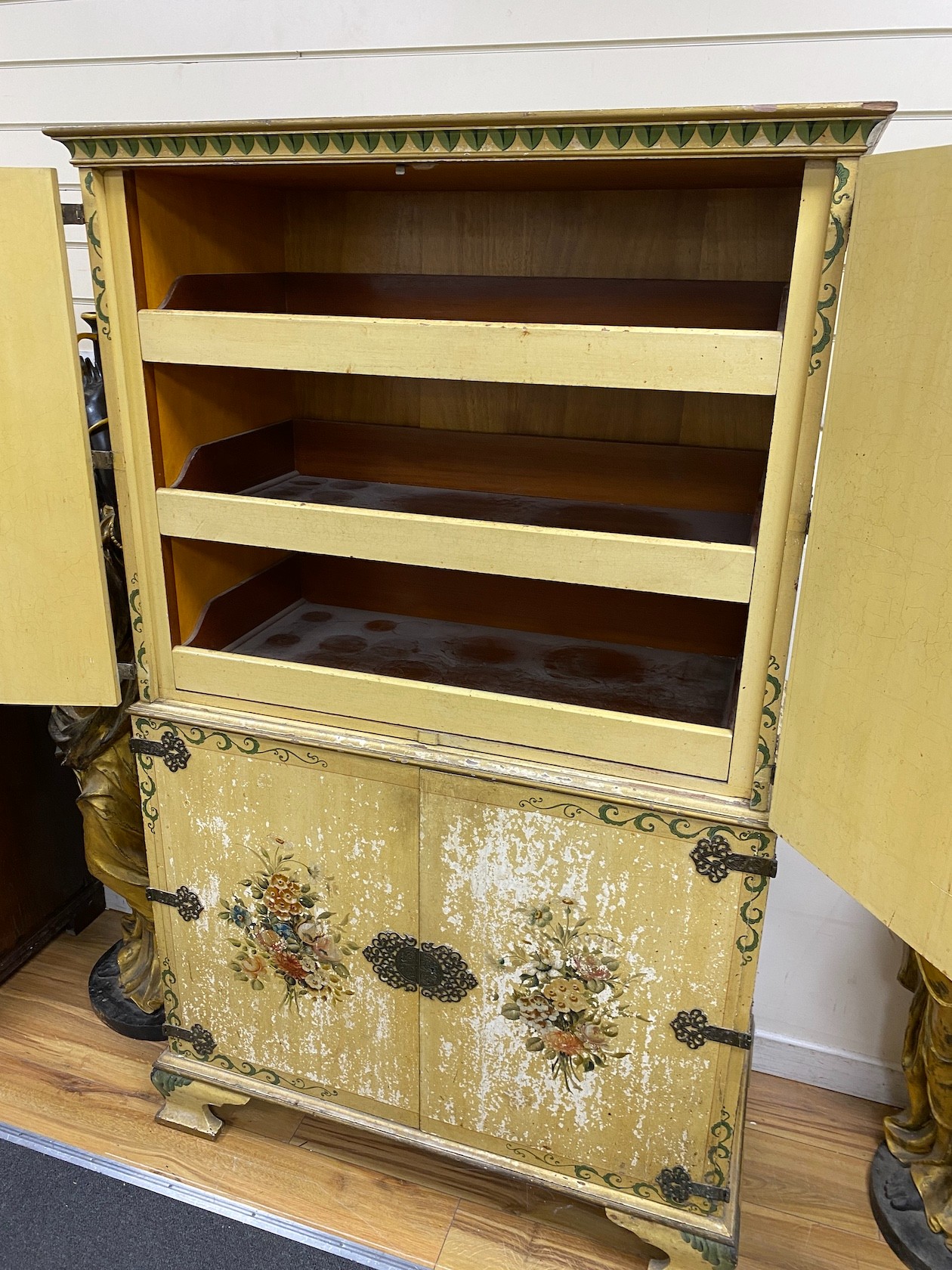 A decorative cream flower painted linen press cupboard, height 168cm, width 104cm, depth 51cm
